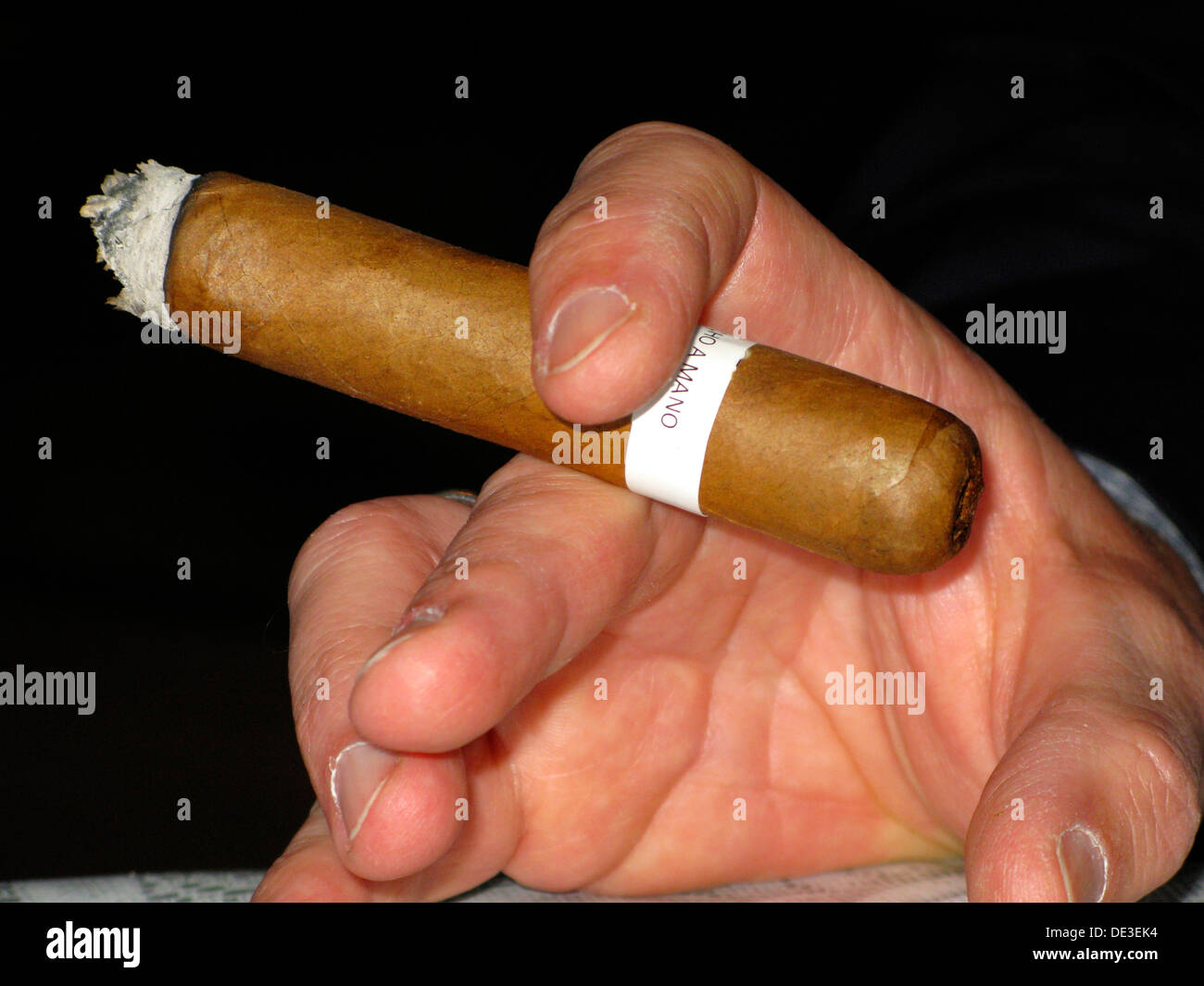 Cigar Held Between a Mans Fingers Stock Photo