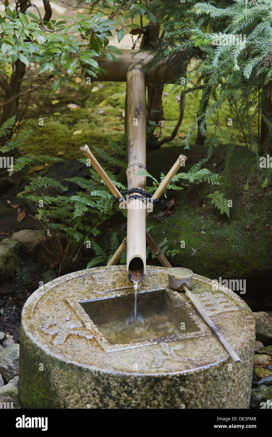 A Japanese Bamboo Fountain Flowing Into A Stone Basin Shaped Like A Japanese Coin Behind Kinkakuji Temple In Kyoto A Japanese Bamboo Fountain Flowing Into A Stone Basin Shaped Like A Japanese Coin Behind Kinkakuji Temple In Kyoto