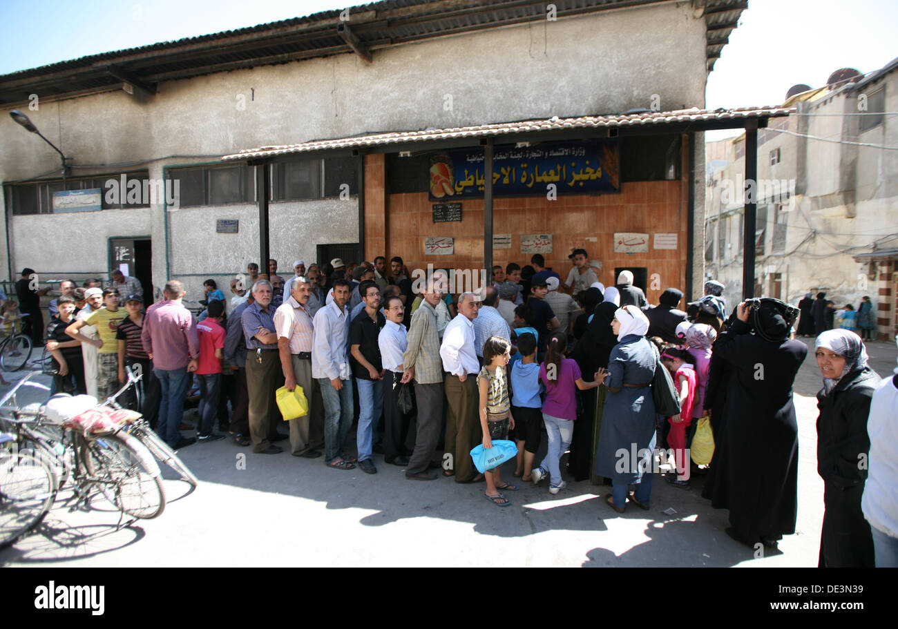 People queue in front of a bakery in Damascus, Syria on September 08, 2013. Photo: Martin Lejeune Stock Photo