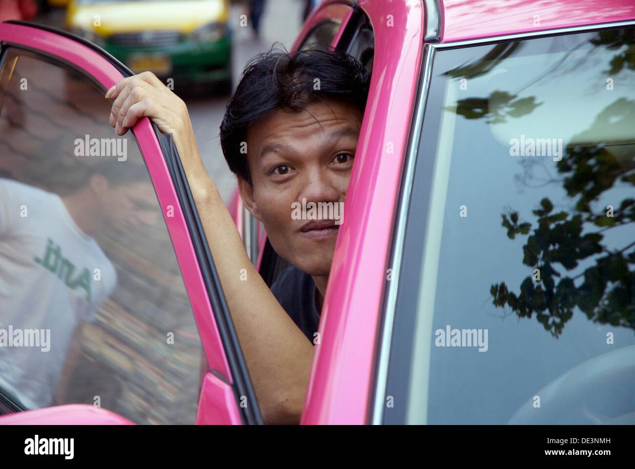 Taxi driver in Bangkok looks out of the Taxi Stock Photo