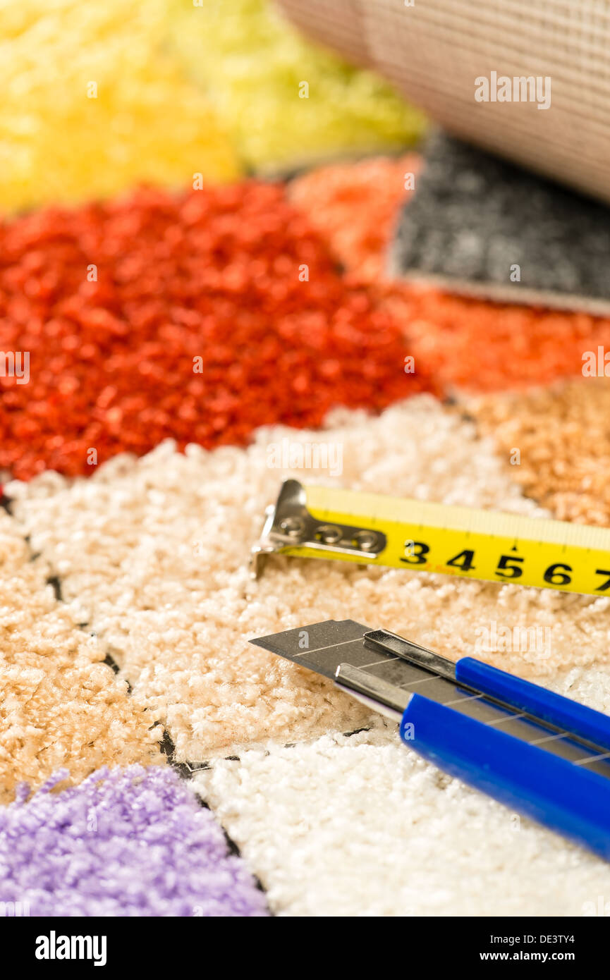 Colorful carpet swatches, tape measure and boxcutter Stock Photo