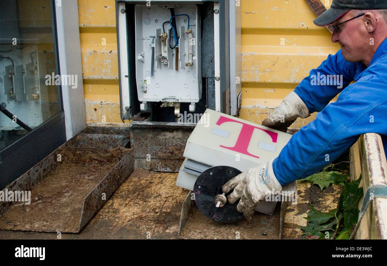 A worker removes an old telephone booth of Deutsche Telekom in Hanover, Germany, 11 September 2013. Photo: Julian Stratenschulte Stock Photo