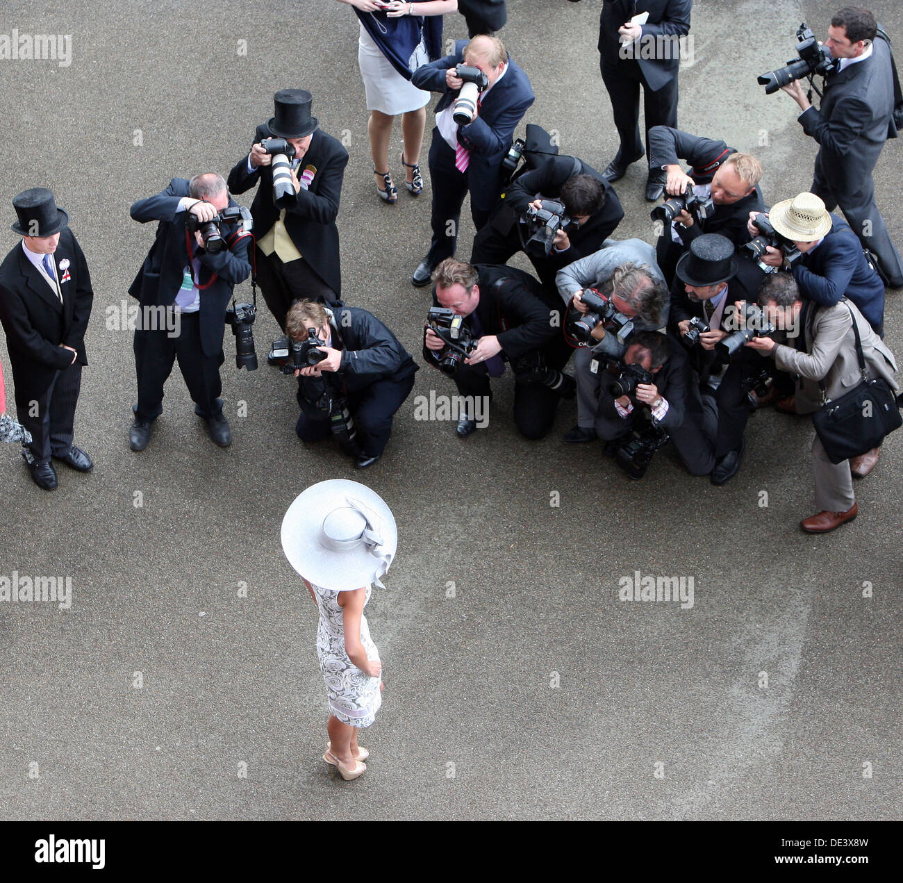 Ascot, UK, elegantly dressed woman with hat posing against a series photographer Stock Photo