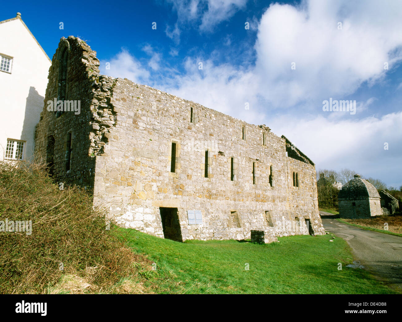Penmon Priory, Anglesey: C13th S range (canons' dining room, cellars below, dormitory above) with C16th warming house at end, dovecote of c 1600 rear. Stock Photo