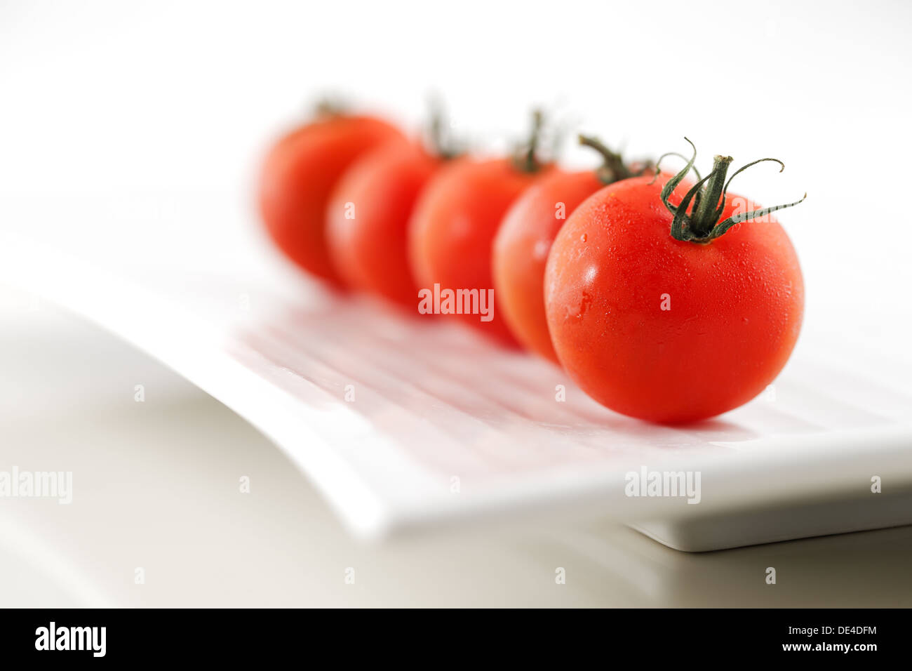 Organic vine tomatoes shot against a white background Stock Photo - Alamy