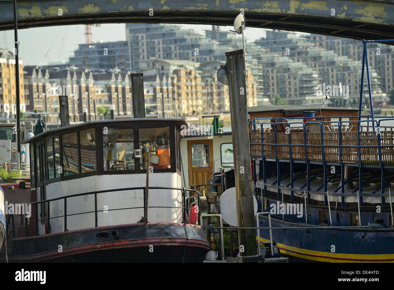 Two old wooden boats anchored at the River Thames with new modern