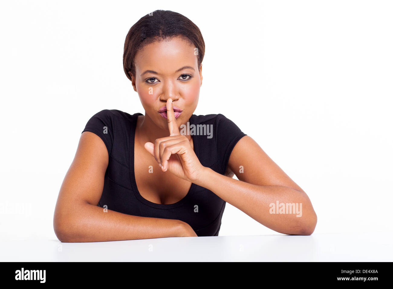 African American woman saying shhh isolated on white background Stock Photo