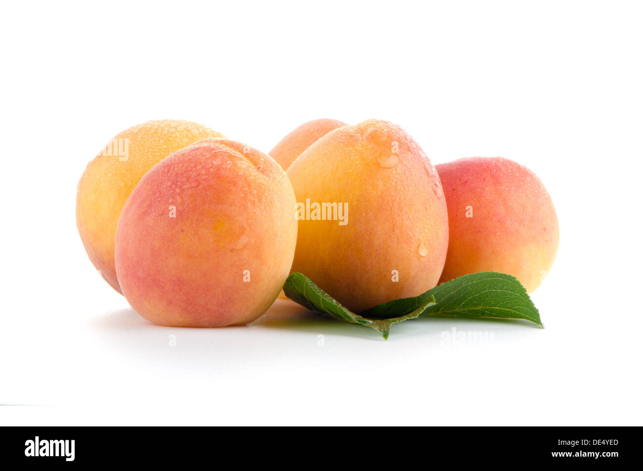 Sweet peaches with leafs on a white background Stock Photo