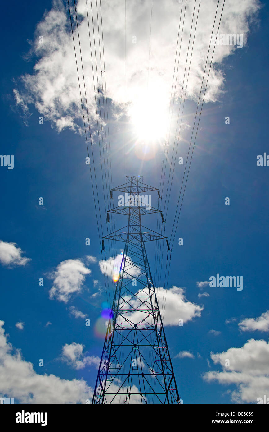 Electricity pylon against a blue sky with clouds Stock Photo