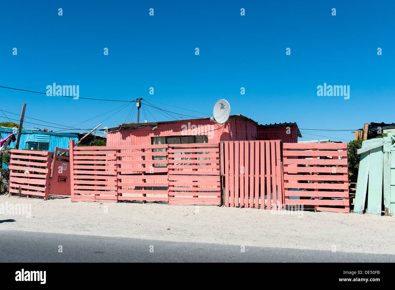 Pink tin shack with satellite dish in Khayelitsha, a partially informal township in Cape Town, South Africa Stock Photo