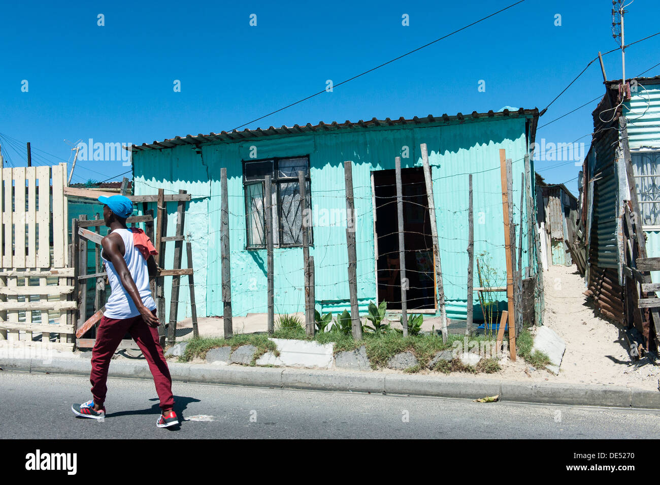 A person walking on the road in Khayelitsha, a partially informal township in Cape Town, Western Cape, South Africa Stock Photo