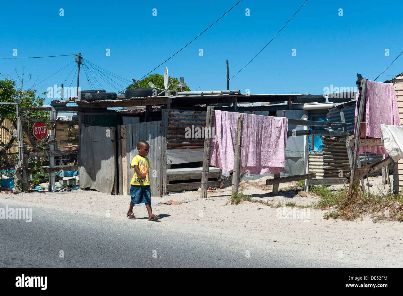 A child walking along a road in Khayelitsha, a partially informal township in Cape Town, Western Cape, South Africa Stock Photo