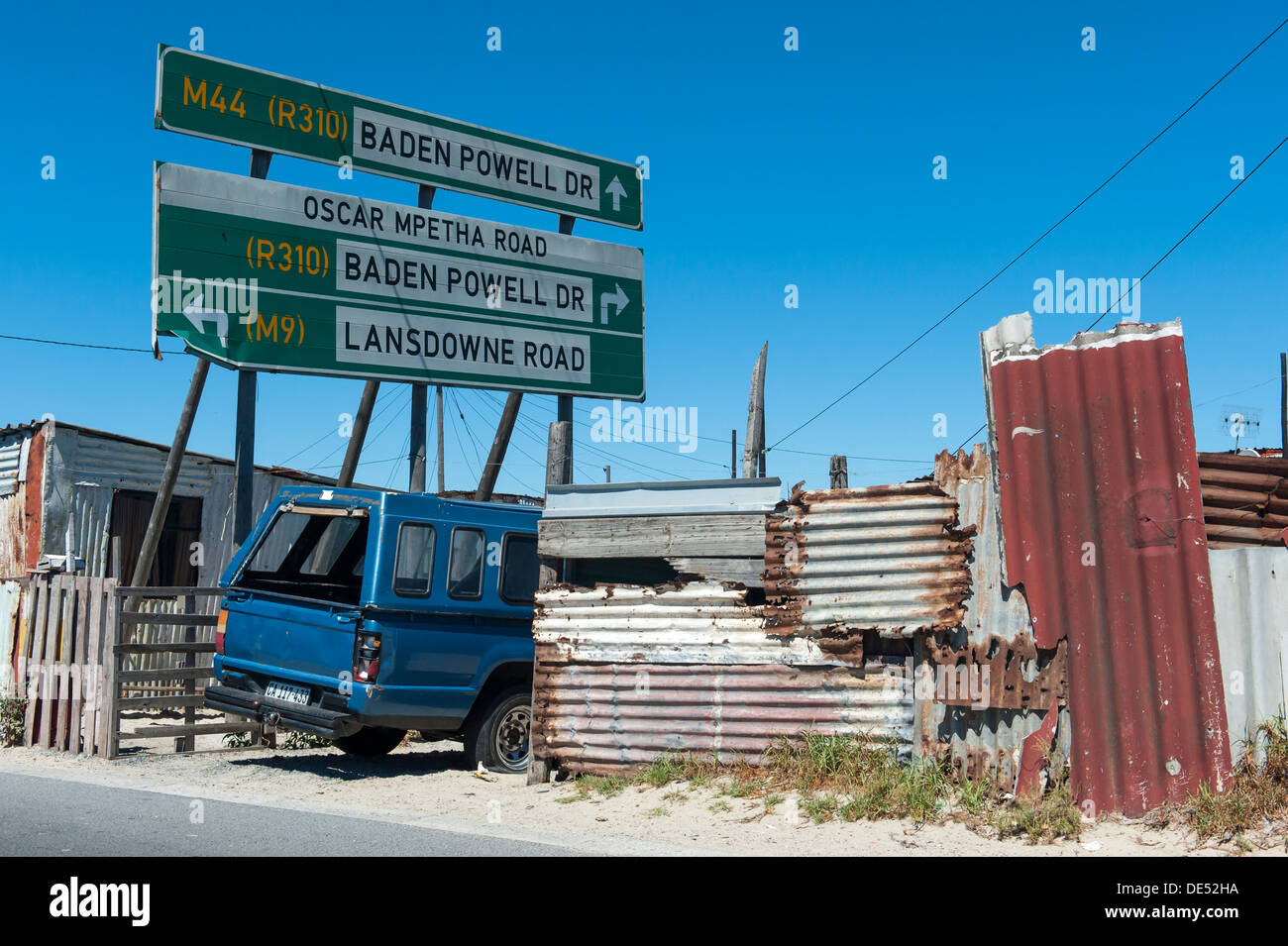 Tin shacks, car and roadsign in in Khayelitsha, a partially informal township in Cape Town, South Africa Stock Photo