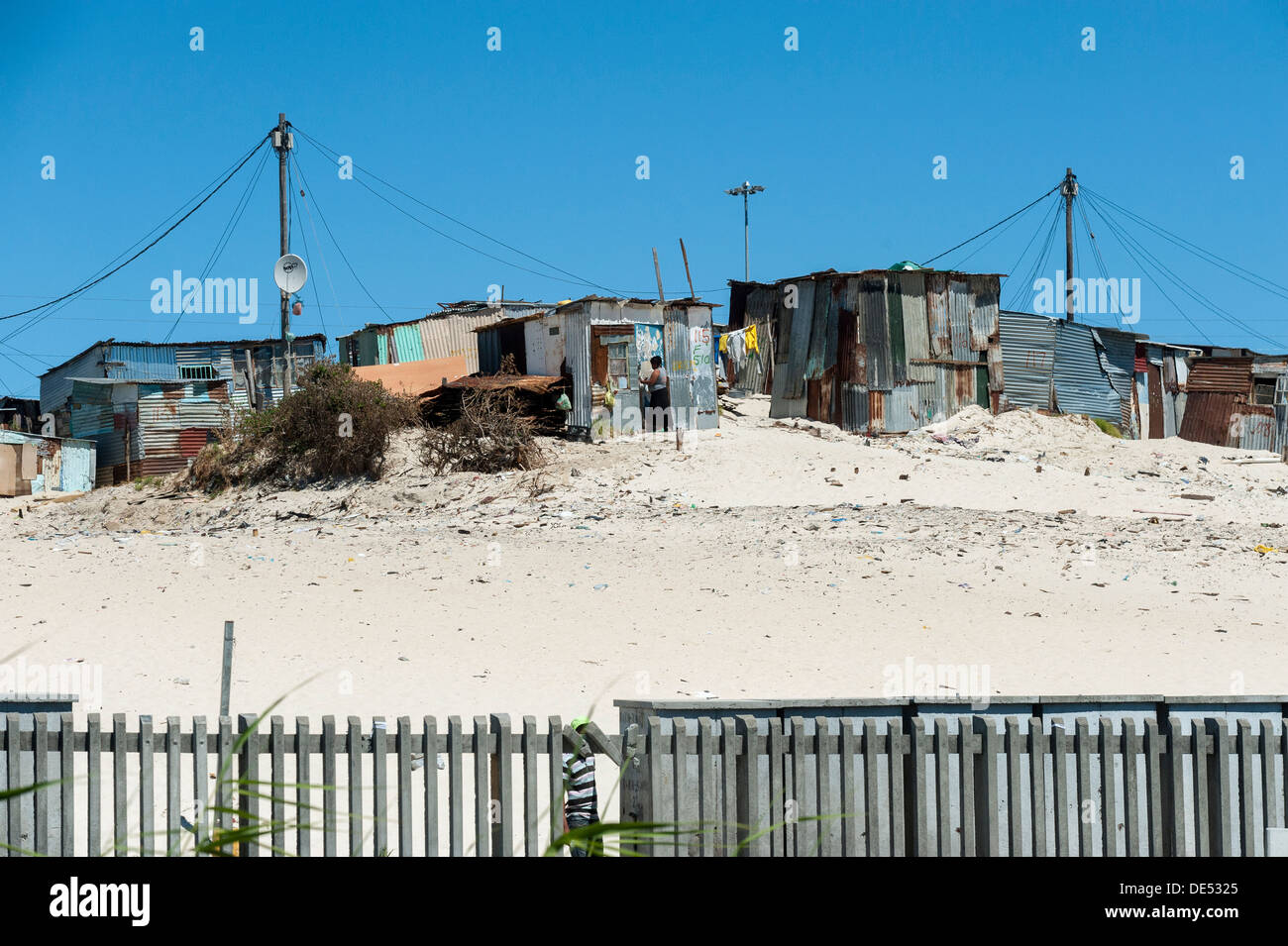 Tin shacks behind a fence in Khayelitsha, a partially informal township in Cape Town, South Africa Stock Photo