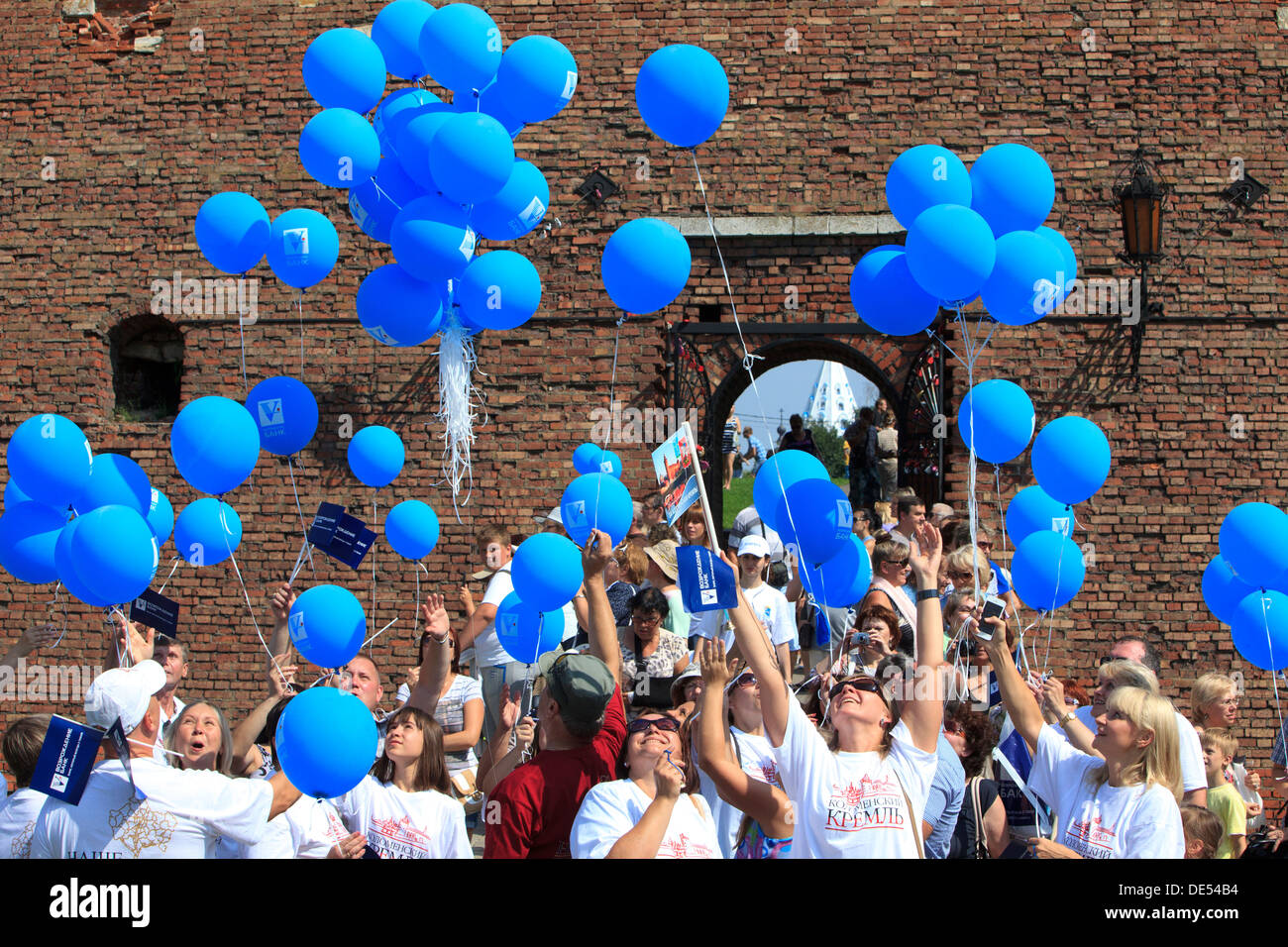 People letting blue balloons go in the air just outside the Mikhailovsky Gate and Bridge at the Kremlin in Kolomna Stock Photo