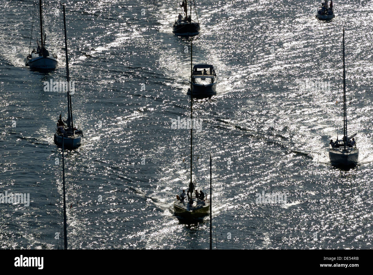 Sailing boats and motorboats in back light Stock Photo Alamy