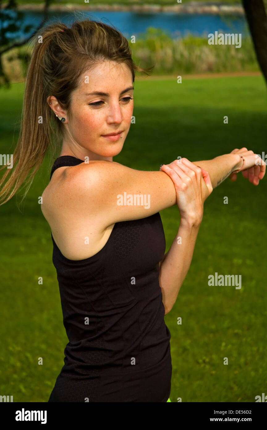 Young woman stretching her shoulderblade. Stock Photo