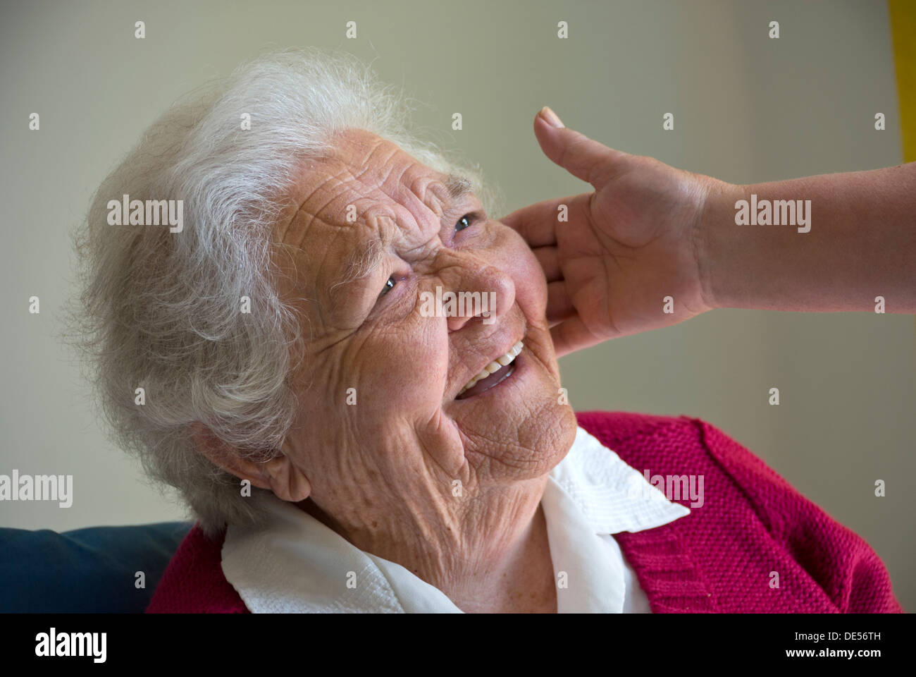 OLD AGE ELDERLY Happy smiling elderly woman with tactile comforting hand of carer Stock Photo