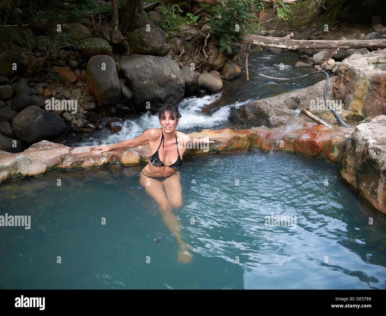 Woman, 45, relaxing in the outdoor pool in 39 degree hot thermal water, Las Pailas, Ricòn de la Vieja National Park Stock Photo