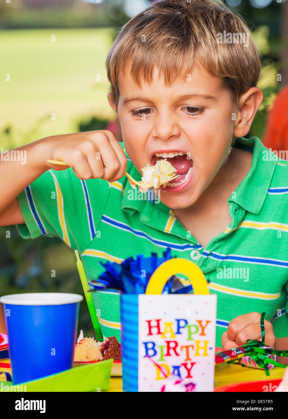 Happy Young Boy Eating Cake at Birthday Party Stock Photo - Alamy