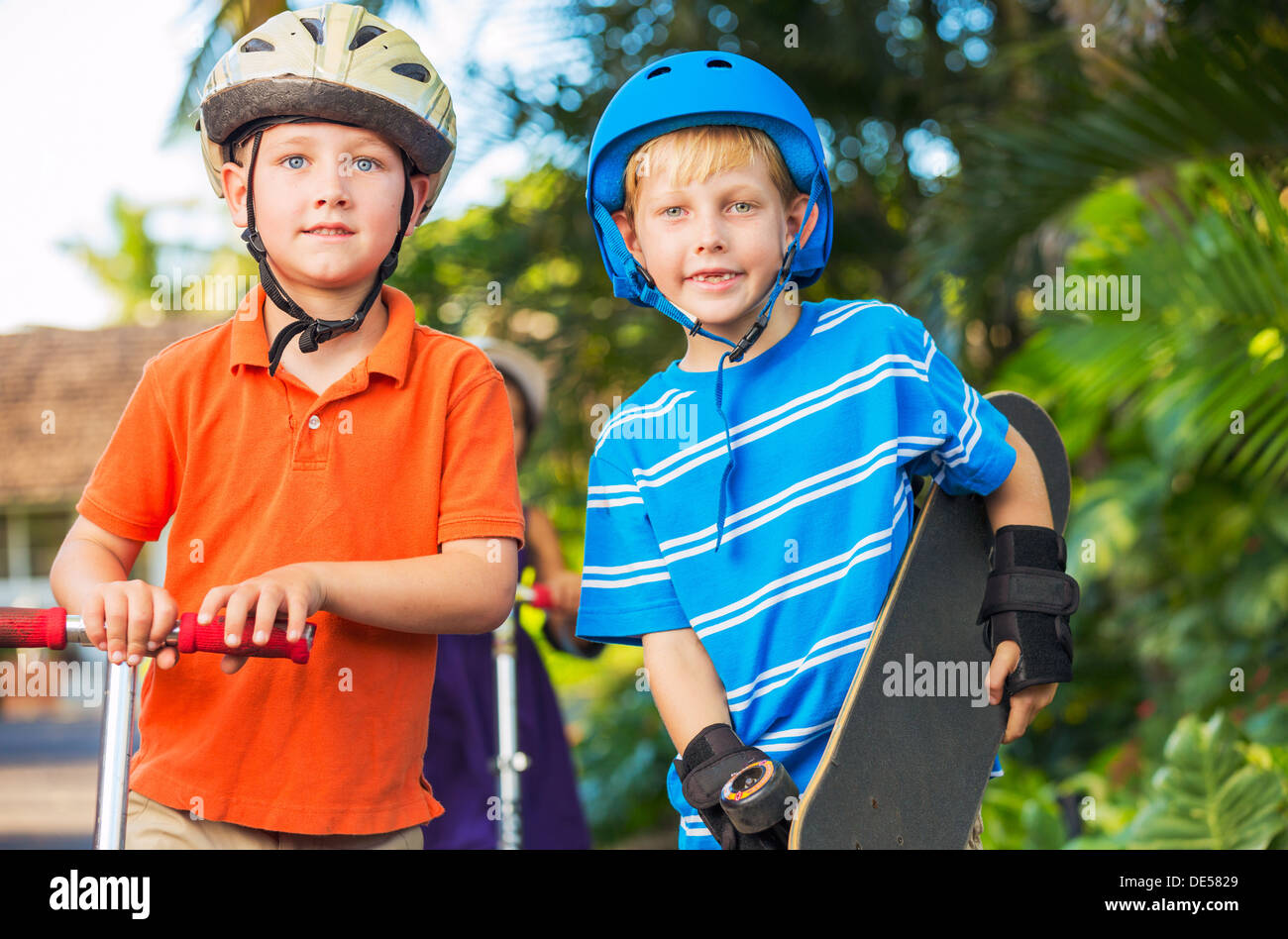 Group of Neighborhood Kids with Skateboards and Scooters Playing Stock Photo