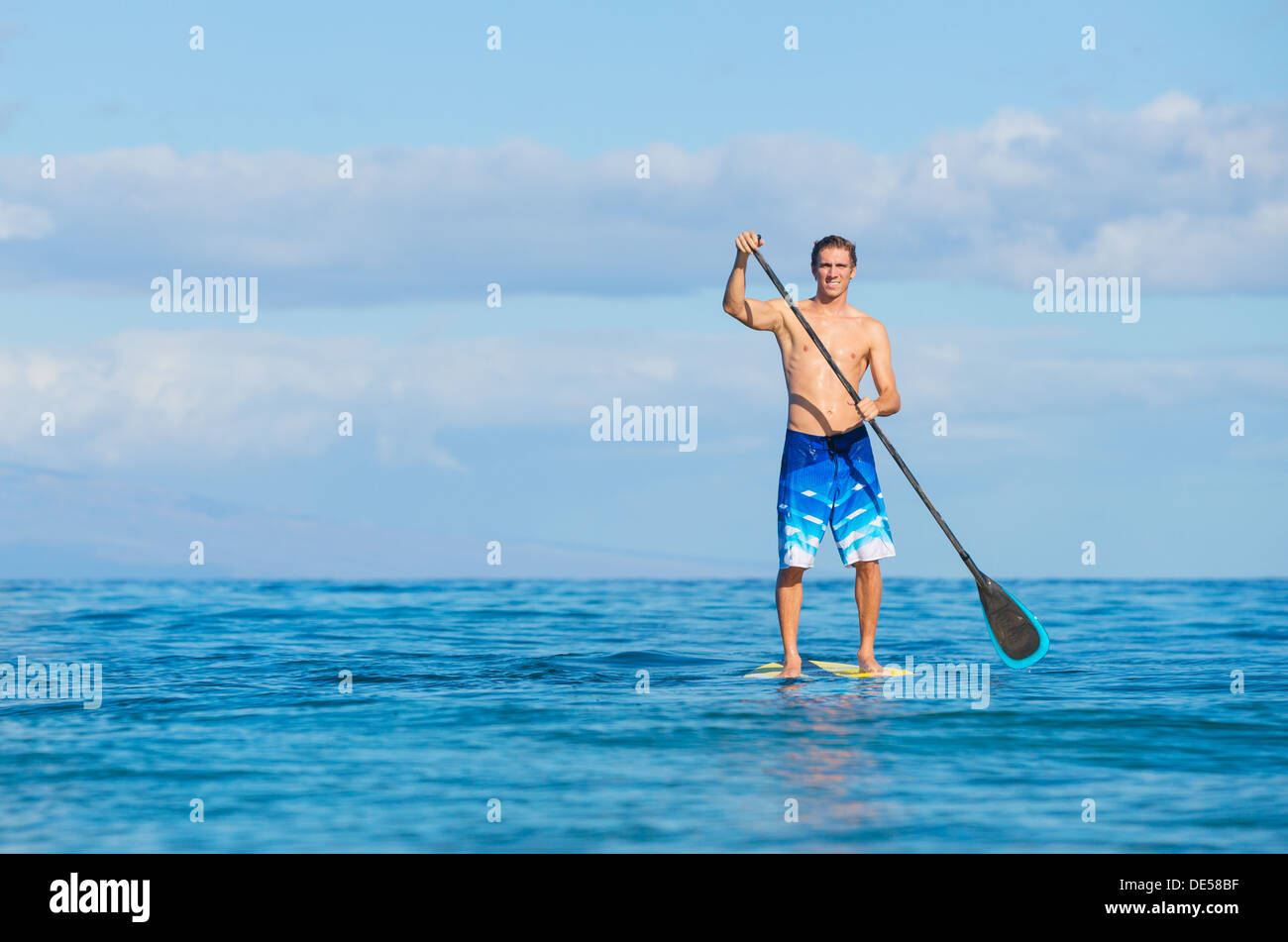 Young Attractive Mann on Stand Up Paddle Board, SUP, in the Blue Waters off Hawaii, Active Life Concept Stock Photo