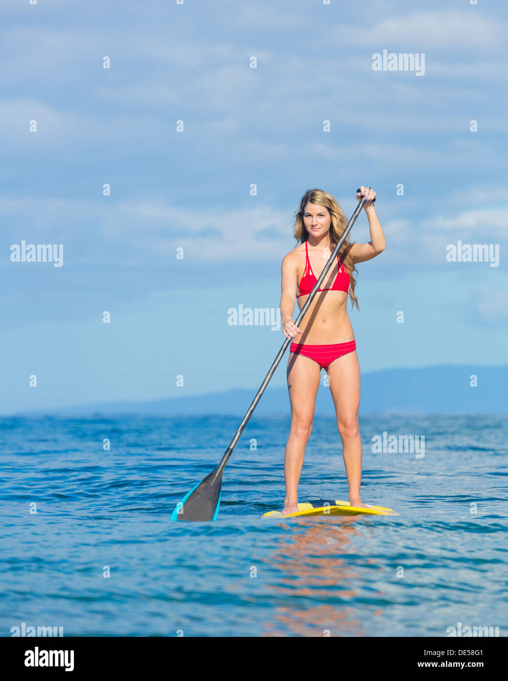 Young Attractive Woman on Stand Up Paddle Board, SUP, in the Blue Waters off Hawaii, Active Life Concept Stock Photo