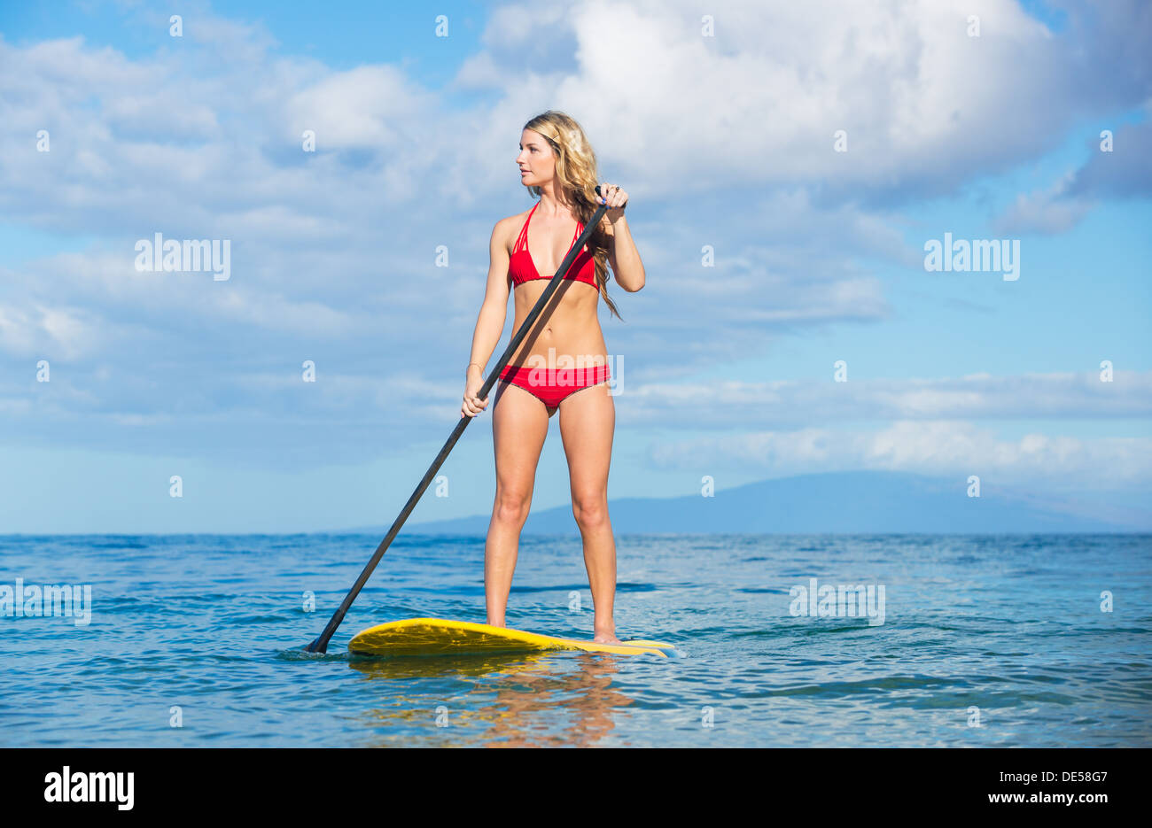 Young Attractive Woman on Stand Up Paddle Board, SUP, in the Blue Waters off Hawaii, Active Life Concept Stock Photo