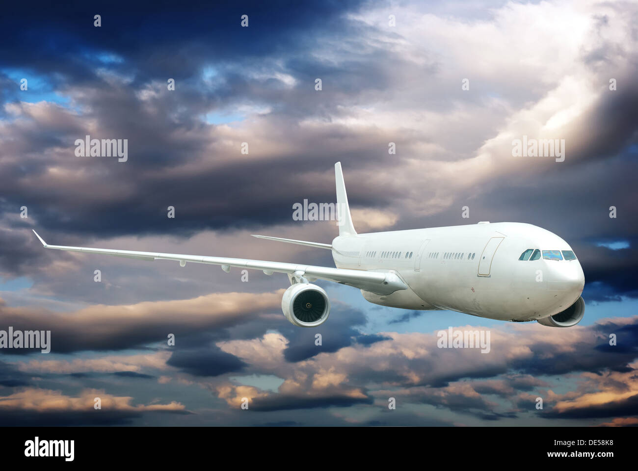 Plane is flying in the sky among light and dark clouds Stock Photo - Alamy