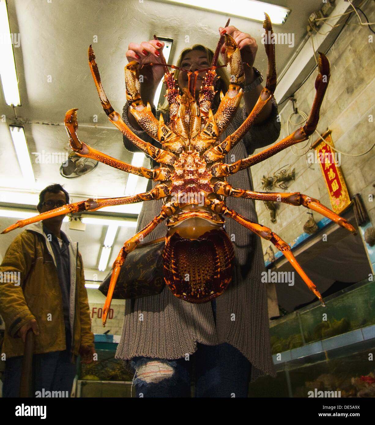 A European tourist holding a gigantic lobster. Stock Photo
