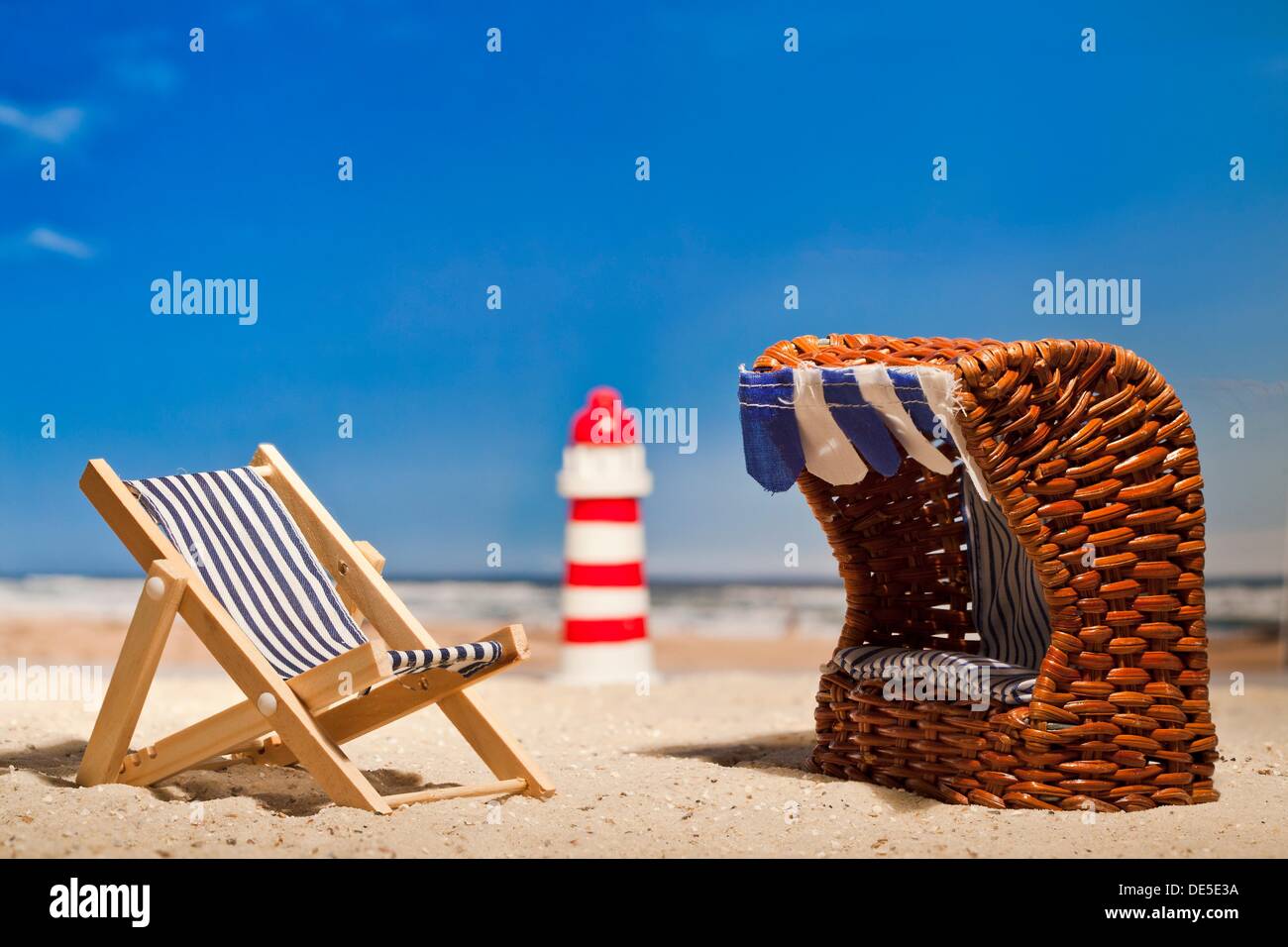 Still Life Of A Miniature Lighthouse Deck Chair And Roofed Wicker