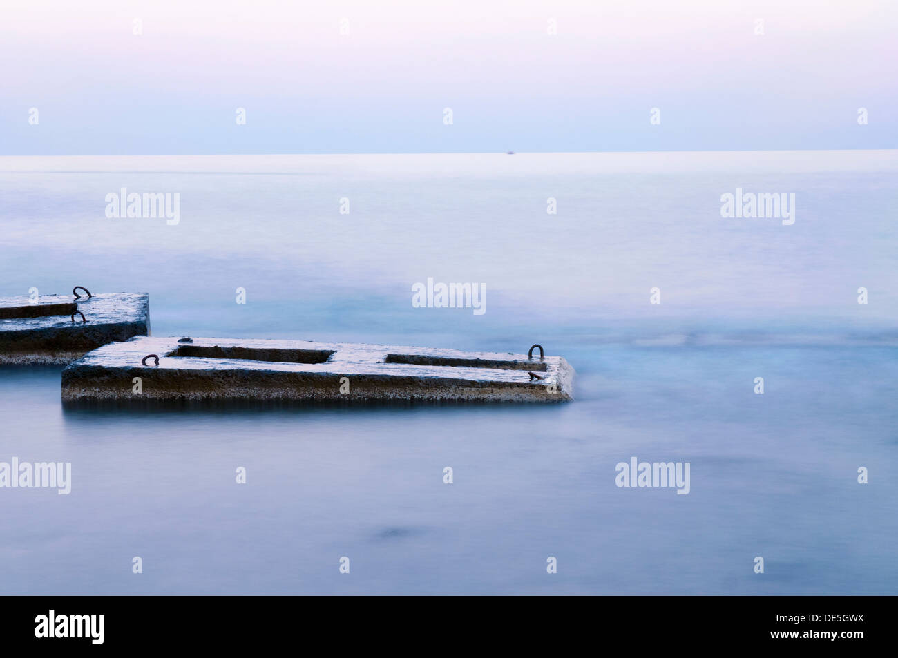 tranquil landscape with concrete structures in sea water at twilight Stock Photo