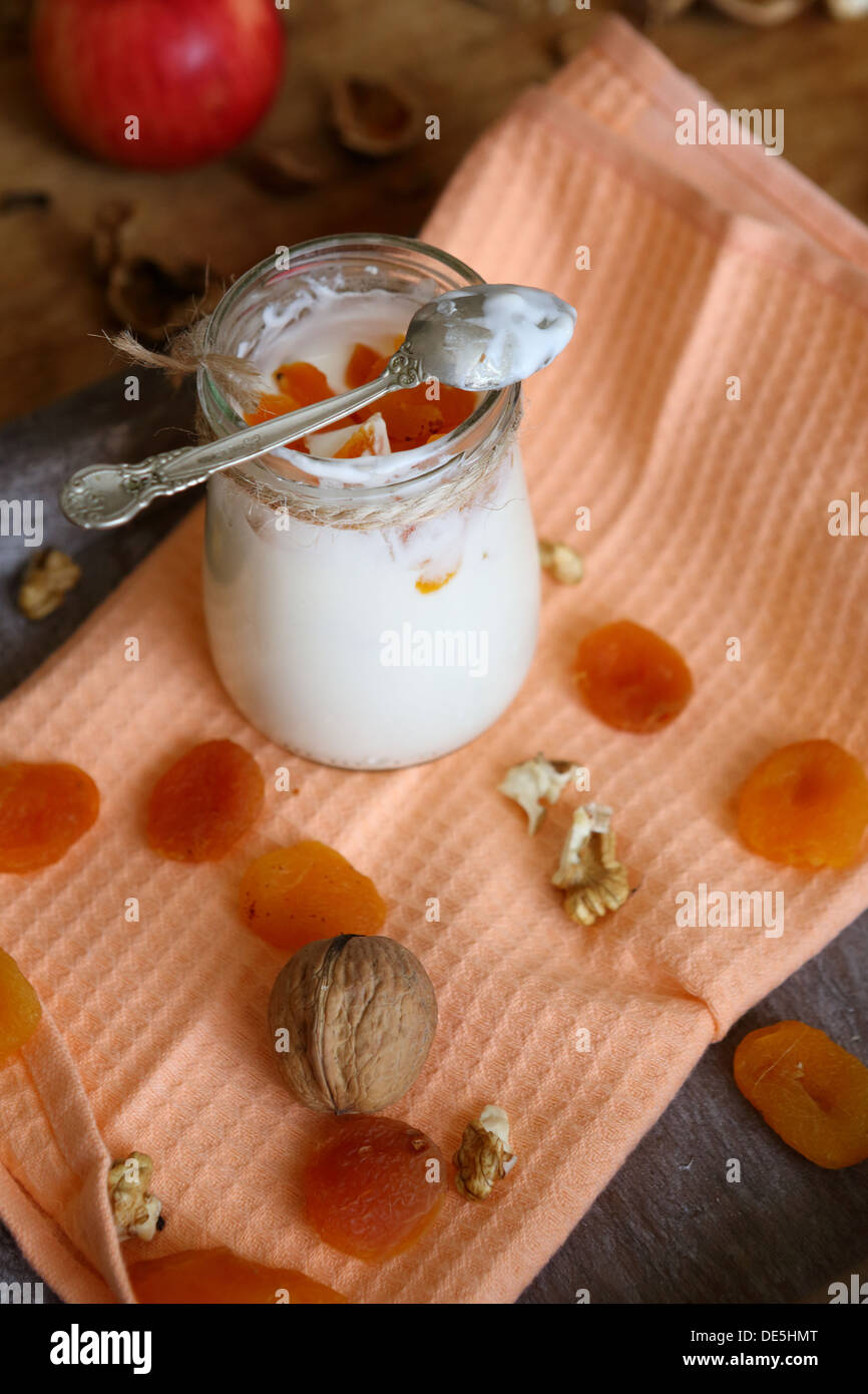 yogurt pot with dried apricots and spoon, top view Stock Photo