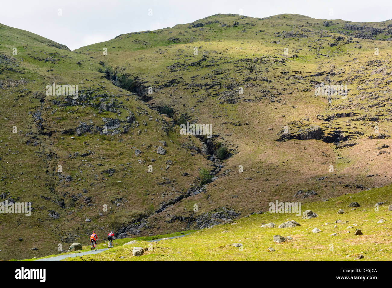 Cyclists climb the steep Wrynose Pass in the English Lake District Stock Photo