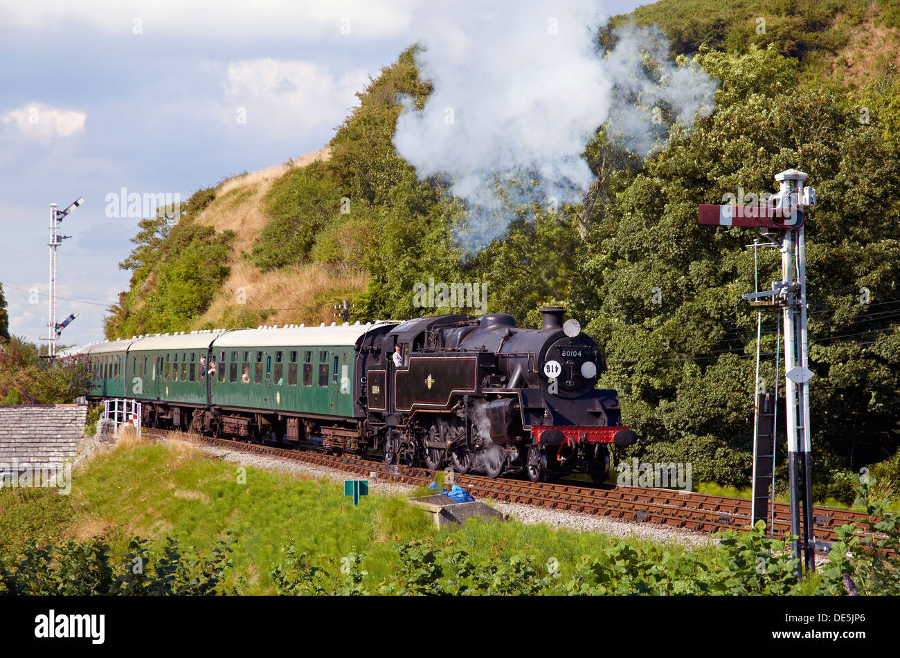 Steam train on the Swanage Railway running into  Corfe Castle station, Dorset, England with a train for Swanage. Stock Photo