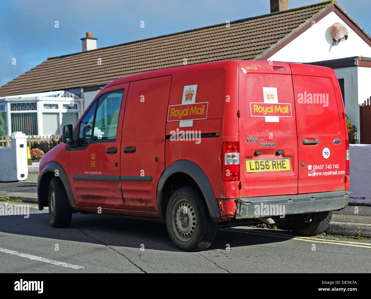 A Royal Mail post delivery van, delivering to residential addresses