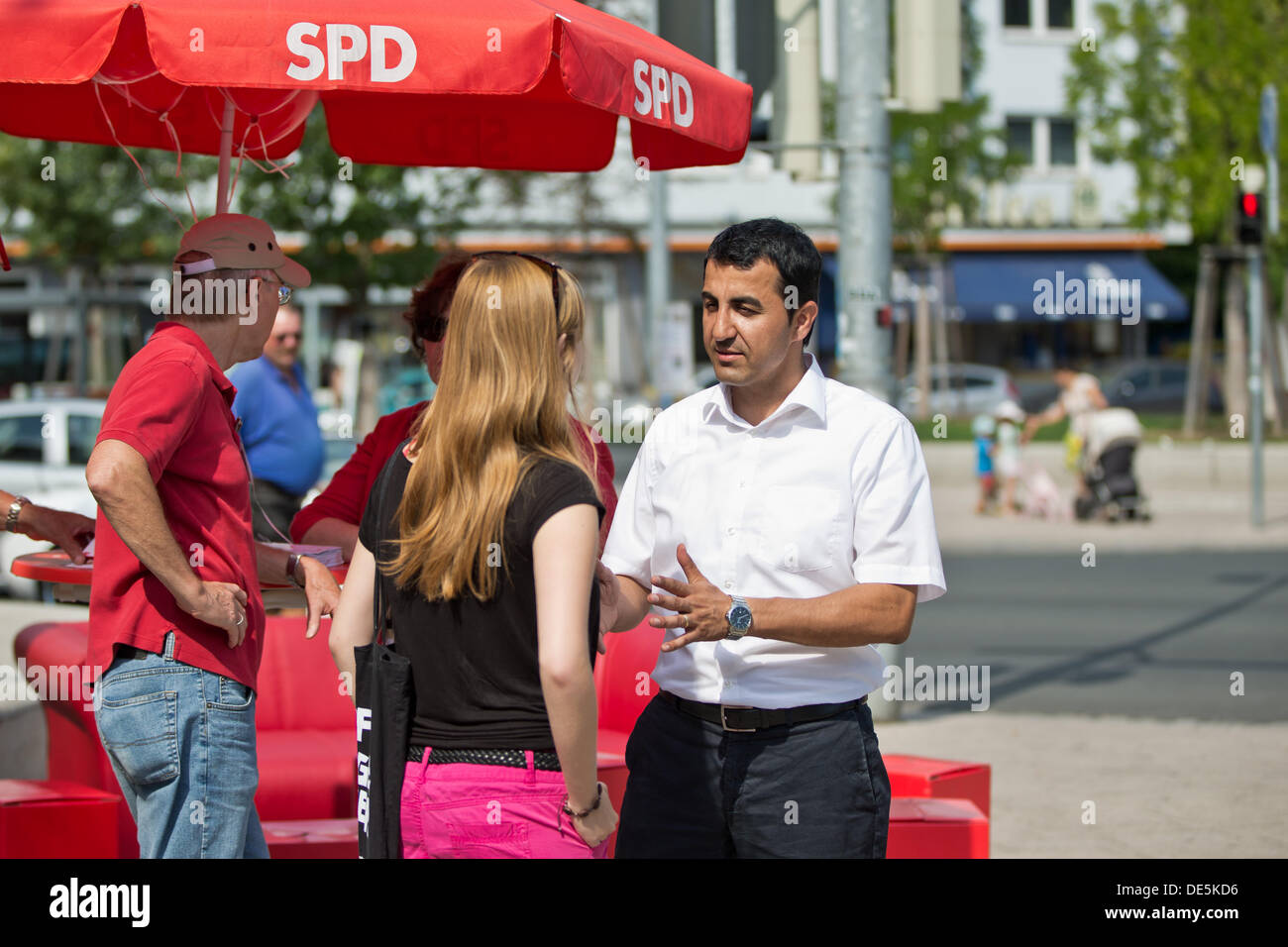 Turkish-born politician Arif Tasdelen talks to a young woman at an election campaign stand of the Social Democratic Party (SPD) in Nuremberg, Germany, 07 September 2013. Photo: Daniel Karmann Stock Photo