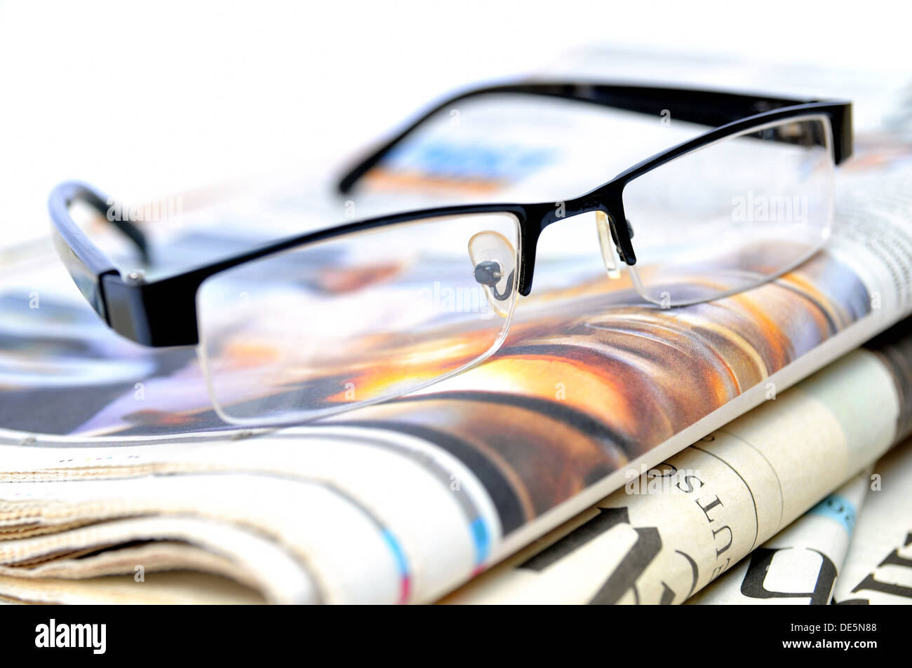 Stack of newspapers with glasses on top Stock Photo