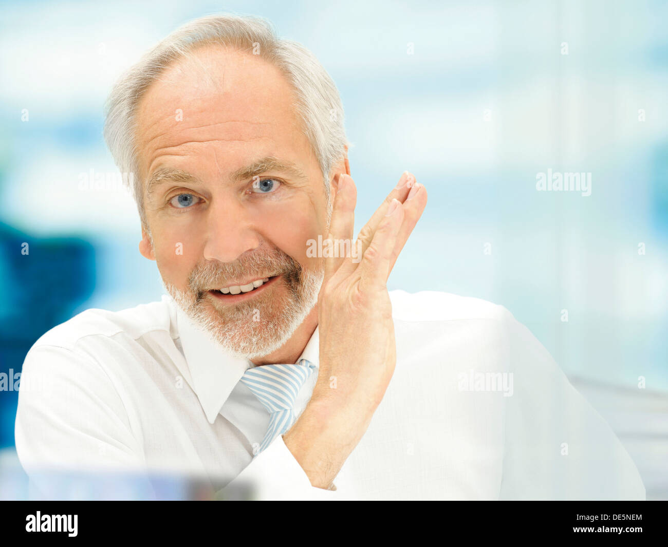 Senior, talking behind his hand, off the record Stock Photo