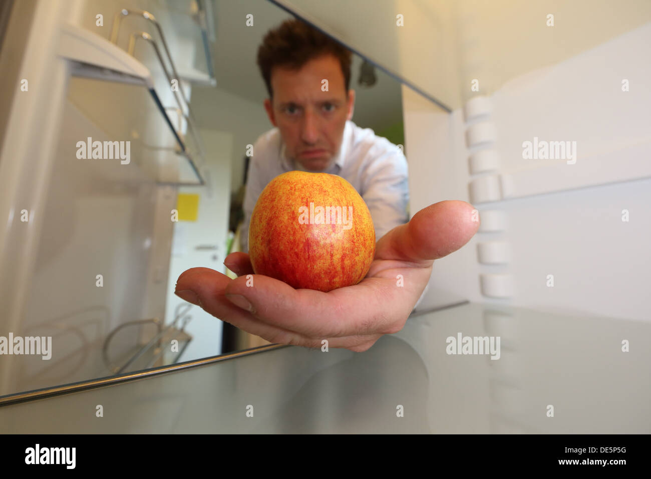 Berlin, Germany, Claus brings an apple from his empty fridge Stock Photo