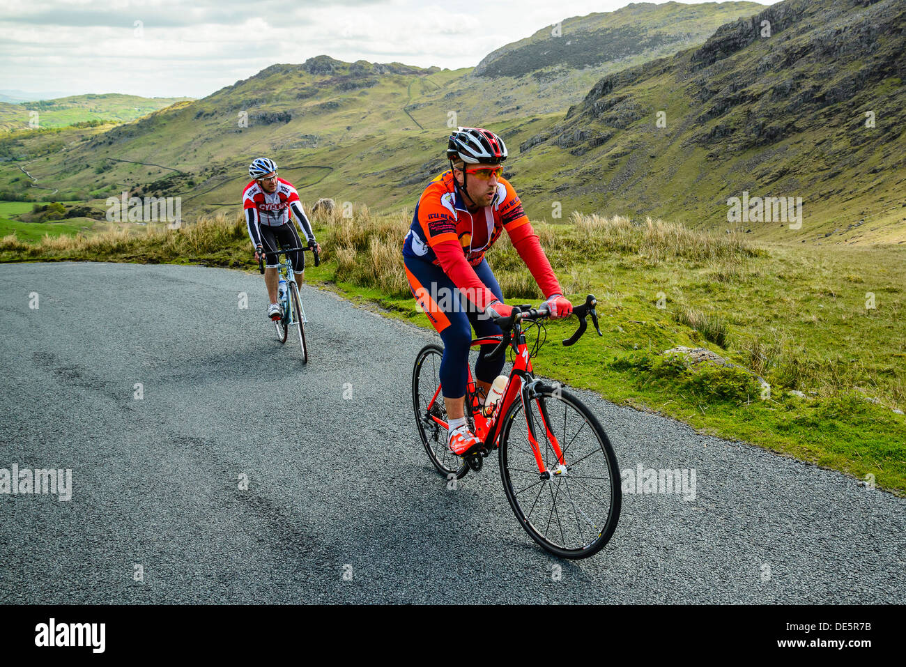 Cyclists climb the steep Wrynose Pass in the English Lake District Stock Photo