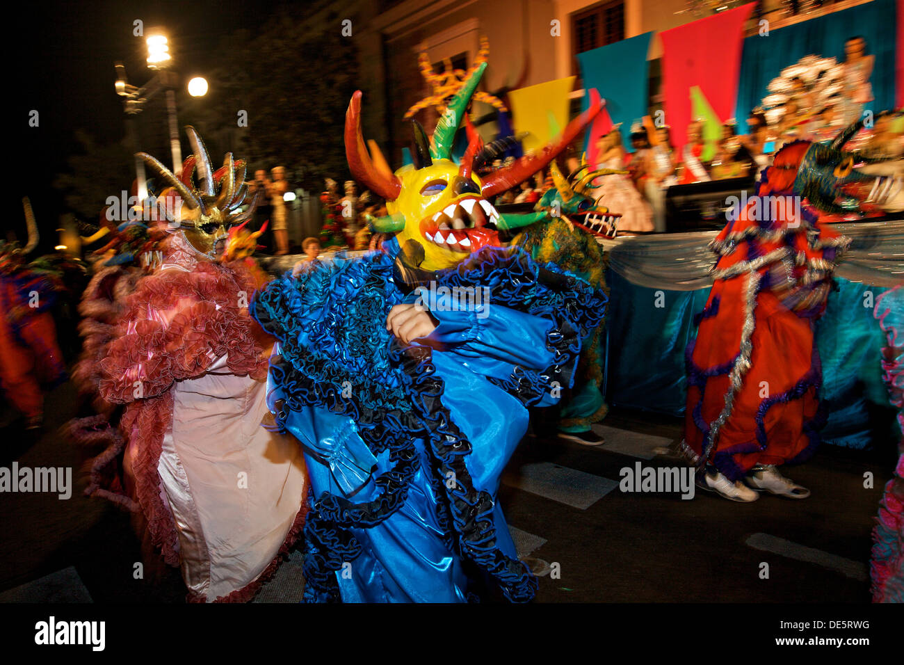 A costumed reveler called a vejigante dances in the streets during the Carnaval de Ponce