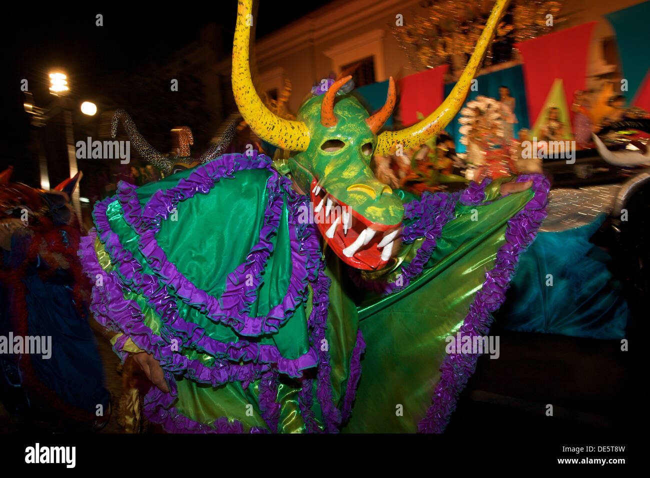 A costumed reveler called a vejigante dances in the streets during the Carnaval de Ponce February 21, 2009 in Ponce, Puerto Rico. Vejigantes are a folkloric character representing the devil. Stock Photo