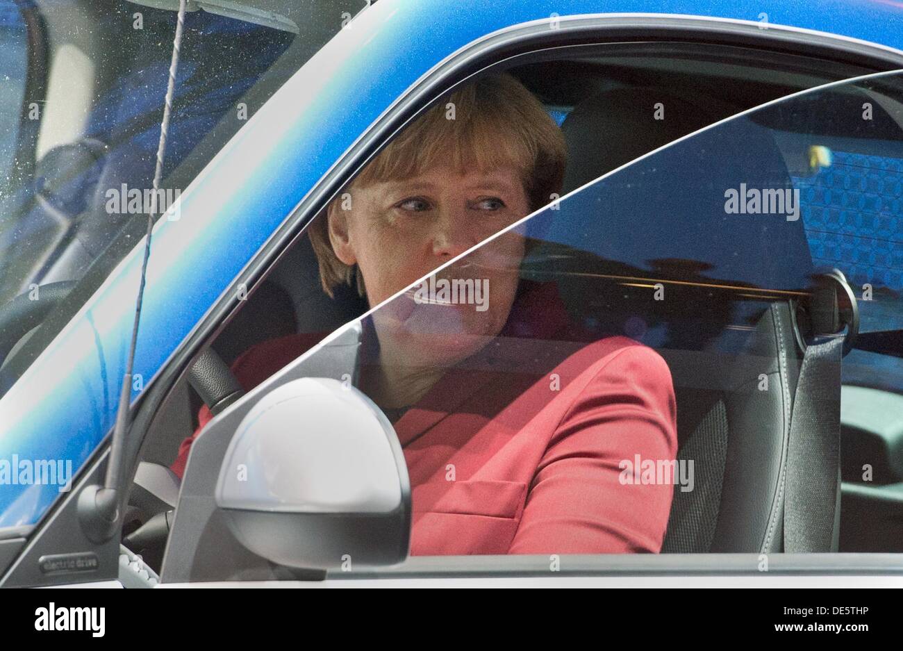 Frankfurt Main, Germany. 12th Sep, 2013. German Chancellor Angela Merkel tests a Smart Electric Drive at the International Motor Show (IAA) in Frankfurt Main, Germany, 12 September 2013. Almost 1100 exhibitors from around the world present novelties at the world's largest automobile show IAA until 22 September 2013. Photo: BORIS ROESSLER/dpa/Alamy Live News Stock Photo