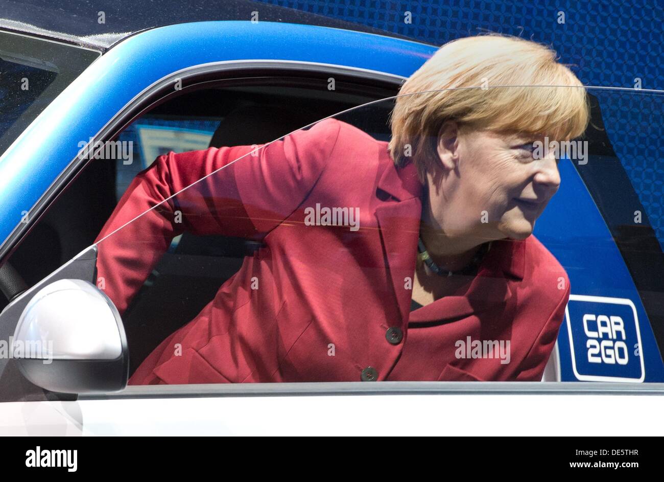 Frankfurt Main, Germany. 12th Sep, 2013. German Chancellor Angela Merkel gets out of a Smart Electric Drive at the International Motor Show (IAA) in Frankfurt Main, Germany, 12 September 2013. Almost 1100 exhibitors from around the world present novelties at the world's largest automobile show IAA until 22 September 2013. Photo: BORIS ROESSLER/dpa/Alamy Live News Stock Photo