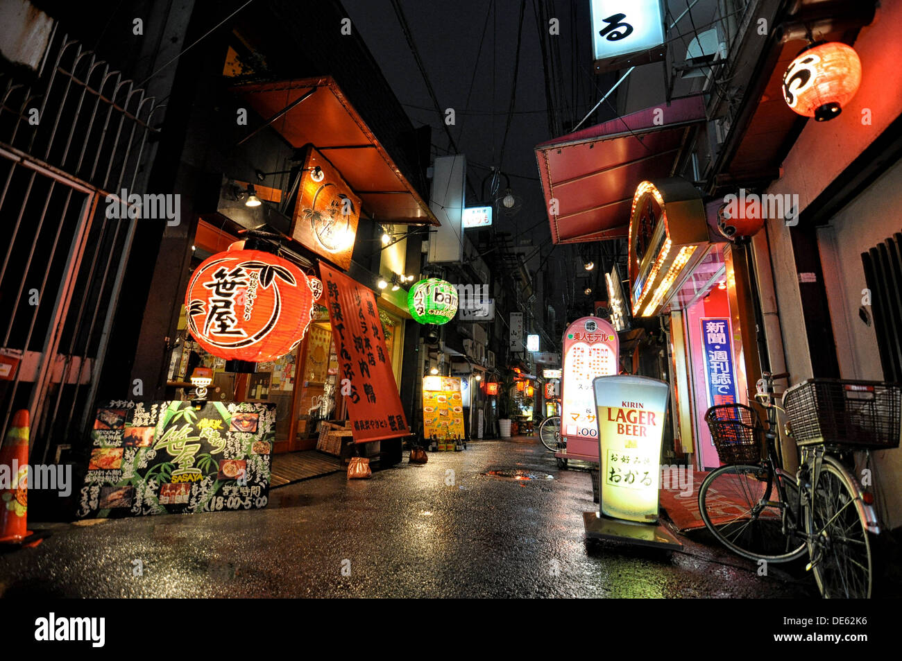 A woman running through rain in the entertainment district of Namba in Osaka, Japan. Stock Photo