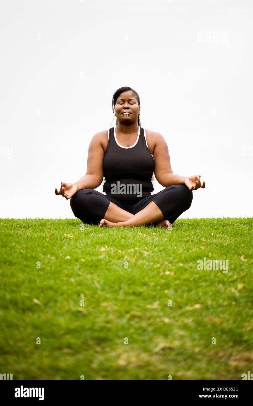 A black plus size female model in Dhyana yoga pose Stock Photo - Alamy