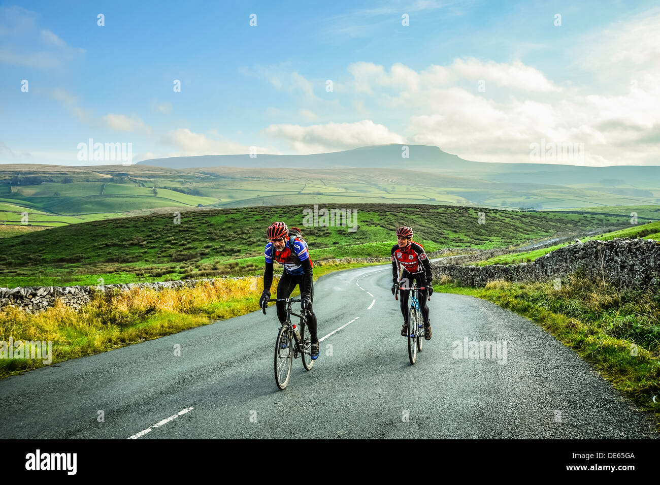 Cyclists in Ribblesdale in the Yorkshire Dales National Park with Pen-y-Ghent behind Stock Photo