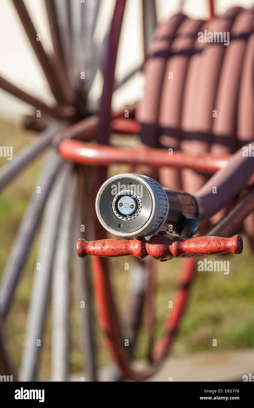 Antique fire hose with nozzle on reel with wooden wheel wagon wheels in Cedar Key, Florida Stock Photo