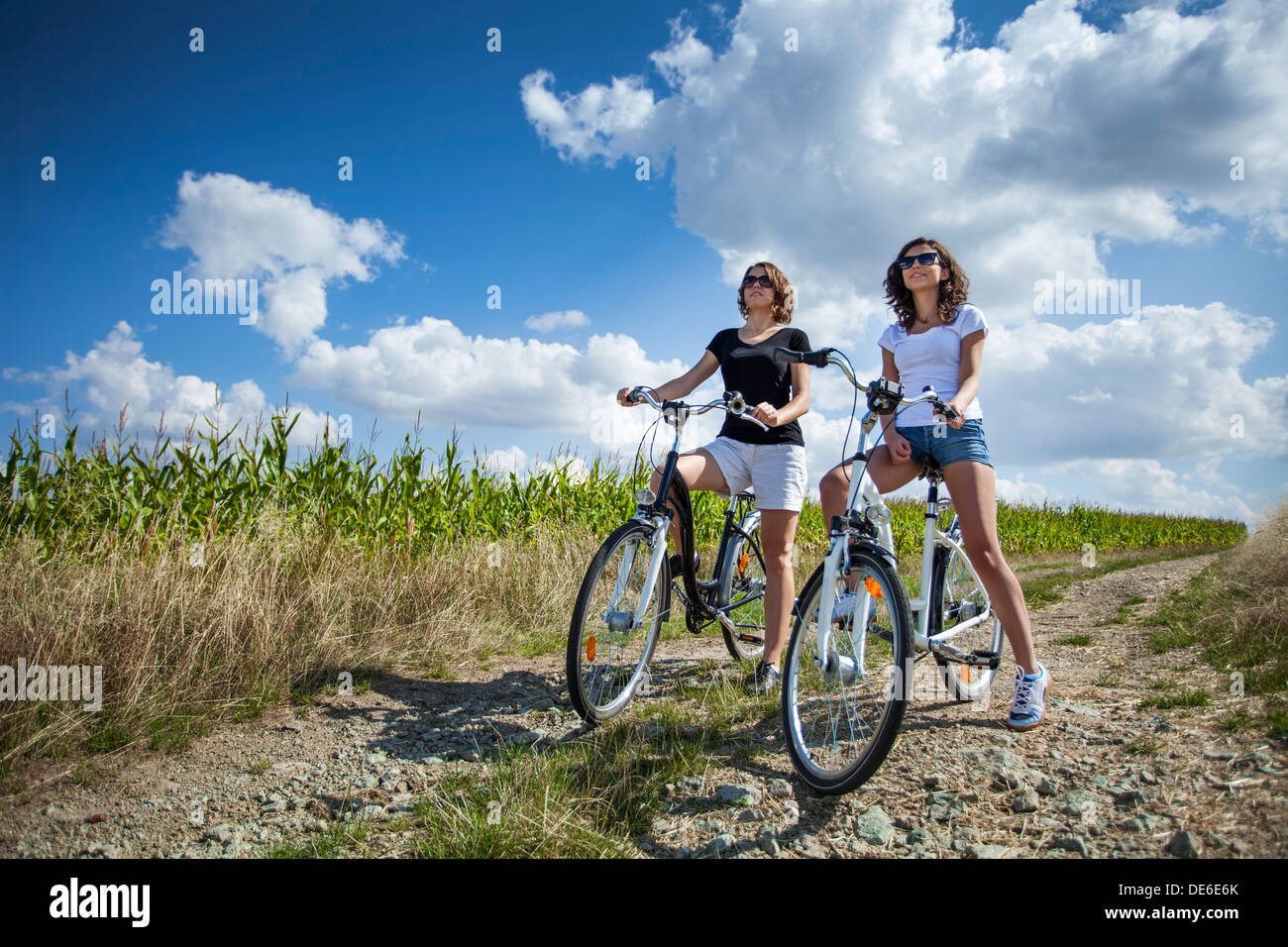 Two pretty girls on bike tour on rock path Stock Photo Alamy